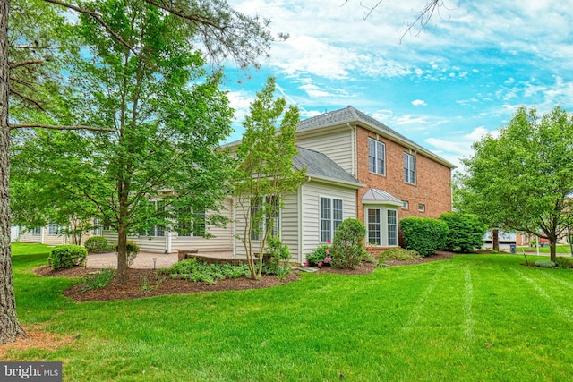 15201 Weiskopf Ct, Haymarket, VA 20169 - back of property featuring a lawn, a shingled roof, and brick siding