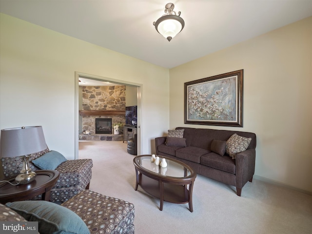 carpeted living area featuring a stone fireplace