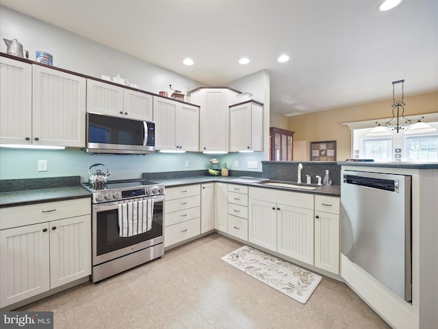 kitchen with a sink, appliances with stainless steel finishes, recessed lighting, and dark countertops