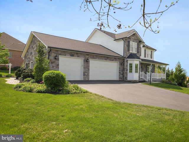 traditional-style home with a front yard, an attached garage, stone siding, and aphalt driveway