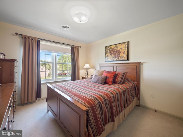 bedroom with visible vents, baseboards, and light carpet