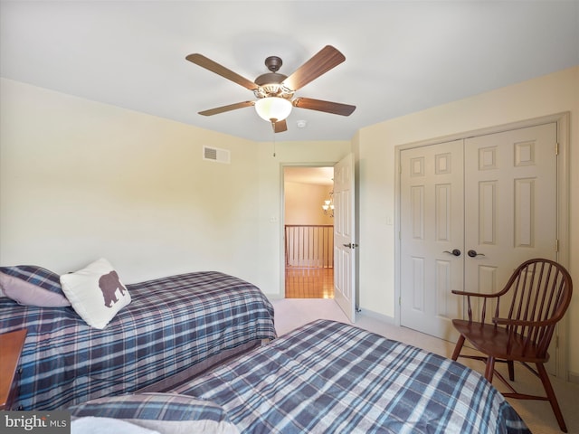 bedroom with visible vents, carpet floors, baseboards, ceiling fan with notable chandelier, and a closet