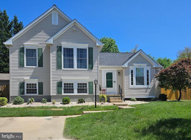 split level home featuring fence and a front yard