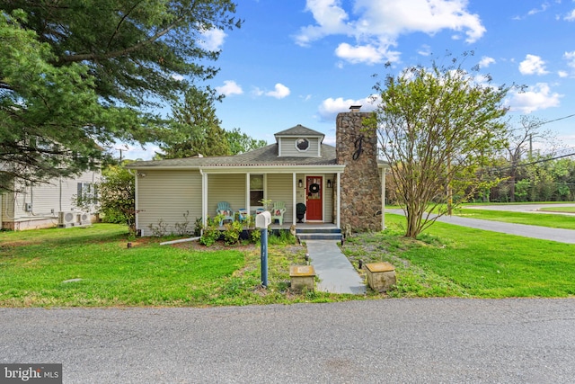 bungalow featuring a chimney, a porch, and a front yard