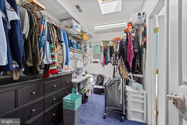 walk in closet with a skylight, visible vents, and carpet