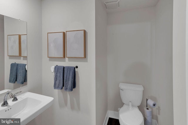 bathroom featuring visible vents, a sink, and toilet
