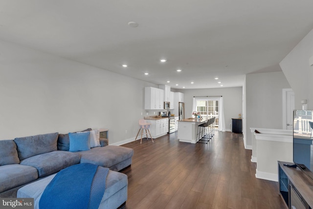 living area featuring recessed lighting, baseboards, dark wood-type flooring, and french doors
