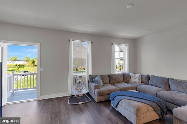 living area featuring baseboards, wood finished floors, and visible vents