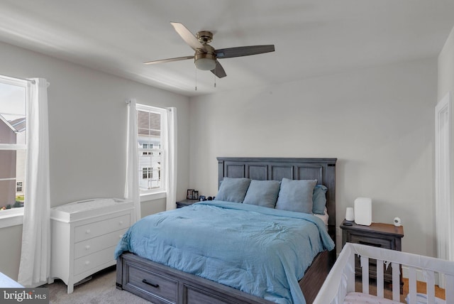 bedroom with a ceiling fan and light colored carpet