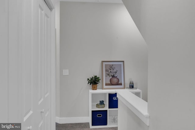 hall featuring baseboards and carpet flooring