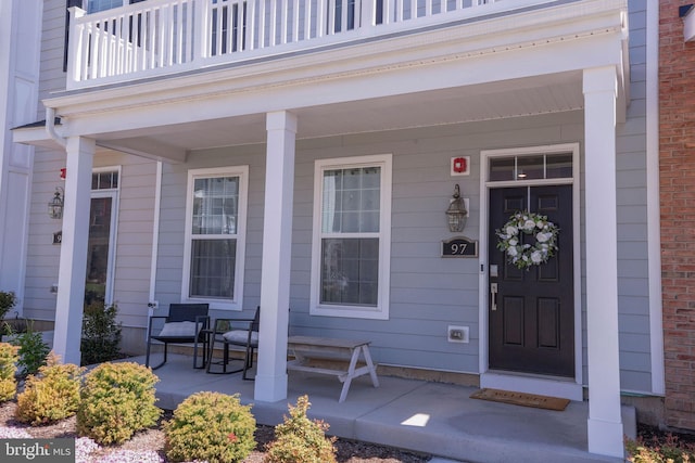 entrance to property with a porch and a balcony