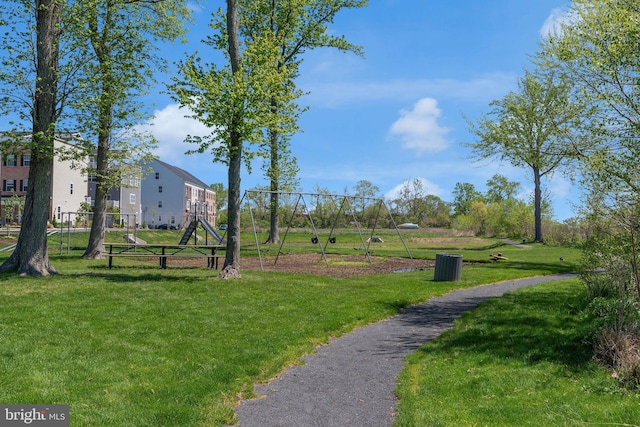 view of property's community featuring a lawn and playground community