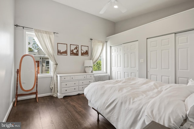 bedroom featuring two closets, baseboards, multiple windows, and radiator heating unit