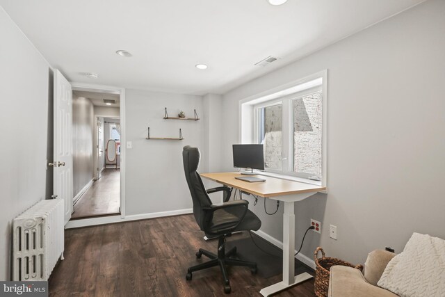 office space featuring baseboards, visible vents, wood finished floors, and radiator