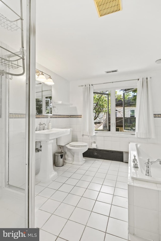 full bath featuring tile walls, visible vents, and a wealth of natural light