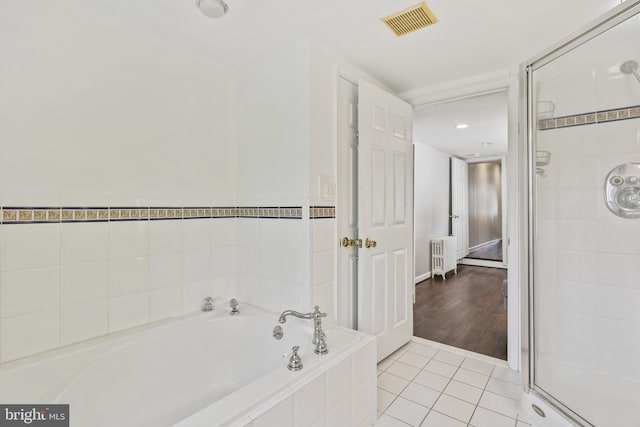 bathroom with visible vents, tile patterned flooring, radiator, a garden tub, and a shower stall