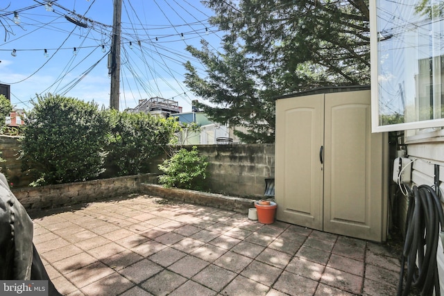 view of patio / terrace featuring a fenced backyard, a storage unit, and an outdoor structure
