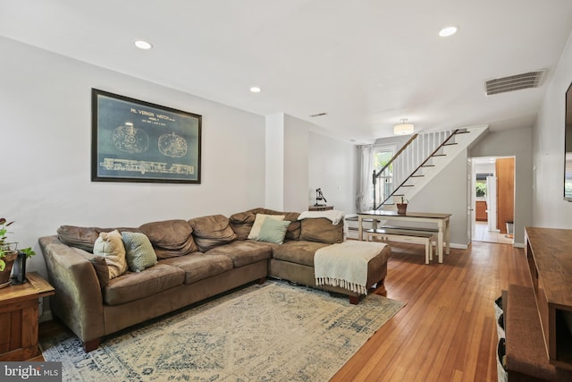 living room with stairs, recessed lighting, visible vents, and hardwood / wood-style flooring