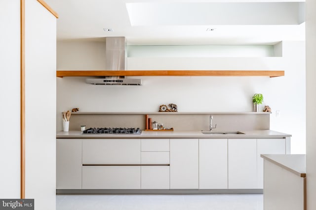 2740 Chain Bridge Rd NW, Washington, DC 20016 - bar featuring stainless steel gas cooktop, extractor fan, light tile patterned flooring, and a sink