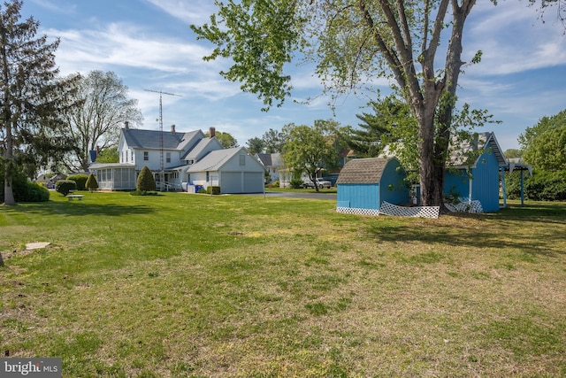 view of yard featuring a storage unit, an outdoor structure, and aphalt driveway