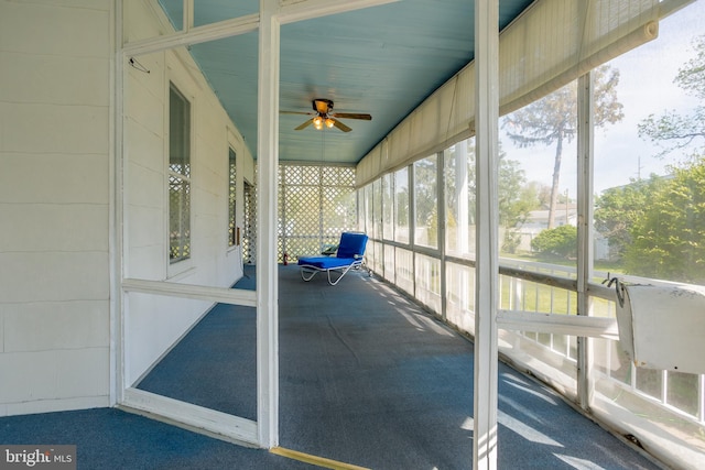 unfurnished sunroom with ceiling fan