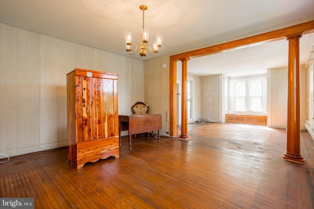 sitting room with ornate columns, a notable chandelier, and hardwood / wood-style flooring
