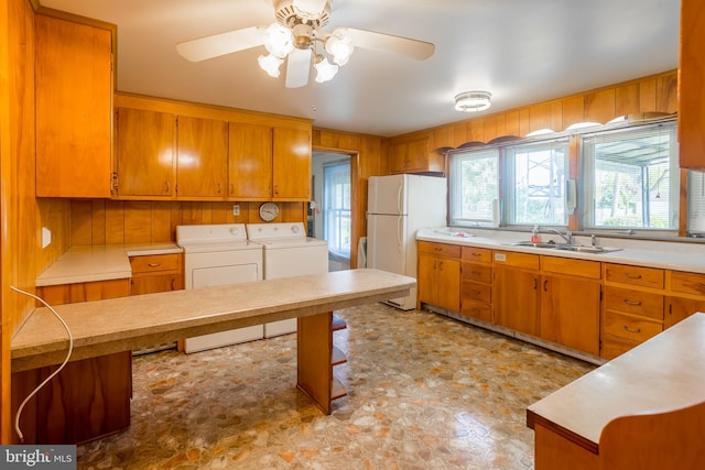 kitchen featuring a sink, washer and dryer, freestanding refrigerator, and light countertops