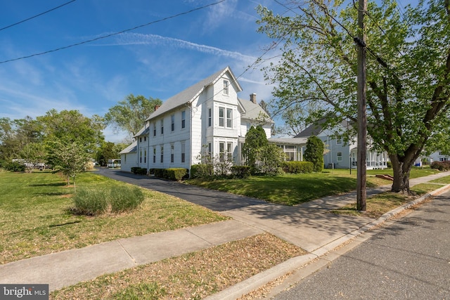 view of front of house with a chimney and a front yard