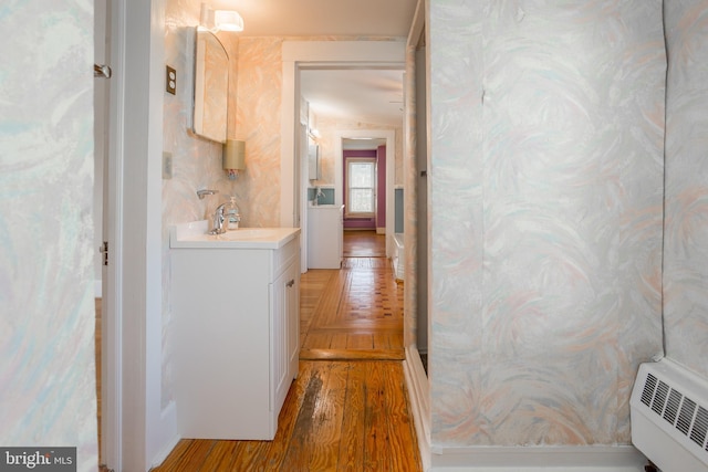hallway with a sink and wood finished floors