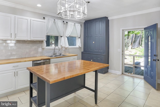 kitchen featuring wood counters, a chandelier, white cabinets, and a sink