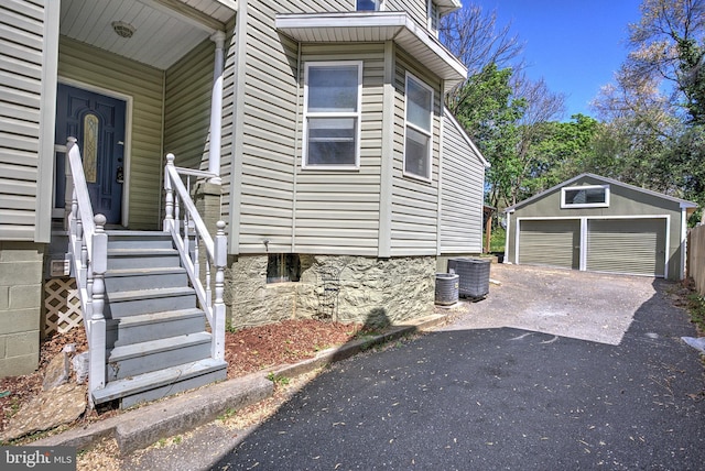 view of side of home with an outdoor structure, a garage, and cooling unit