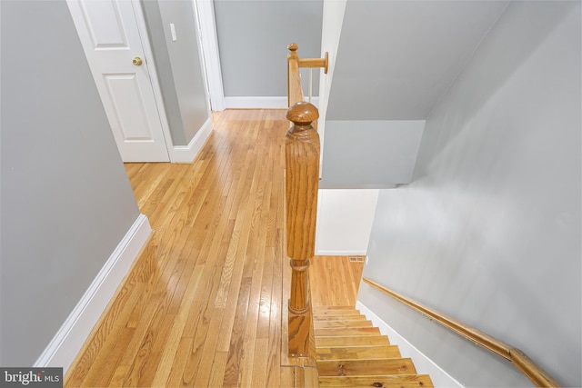 stairway featuring baseboards and hardwood / wood-style flooring