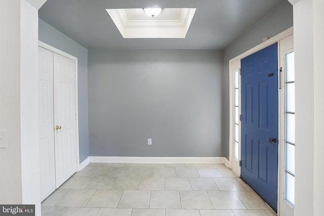 foyer featuring crown molding, plenty of natural light, baseboards, and a raised ceiling