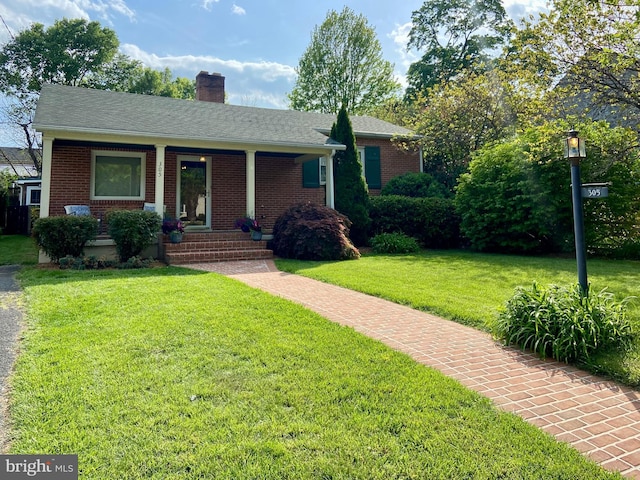 305 W Whitlock Ave, Winchester, VA 22601 - view of front of home with a front yard, a chimney, brick siding, and covered porch