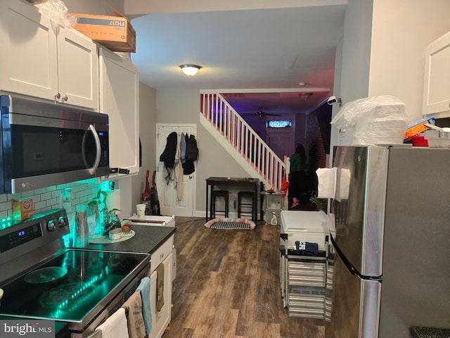 959 Bennett Pl, Baltimore, MD 21223 - kitchen with stainless steel appliances, dark wood-type flooring, white cabinets, and a ceiling fan