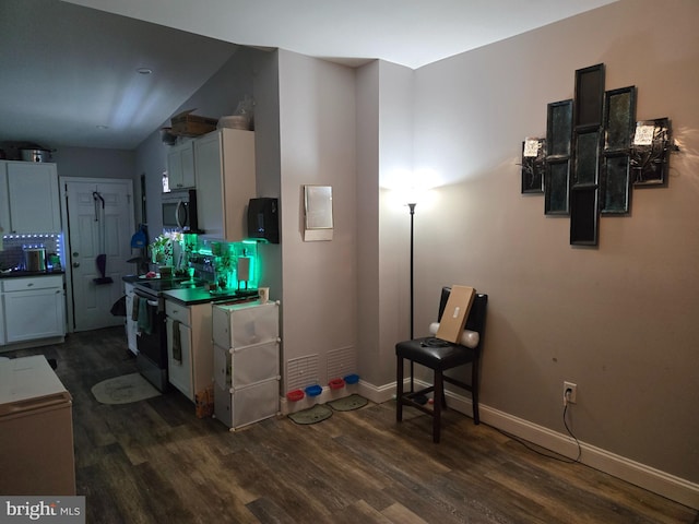 959 Bennett Pl, Baltimore, MD 21223 - kitchen featuring electric range, stainless steel microwave, dark wood finished floors, and baseboards