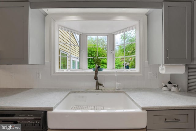 room details with light countertops, gray cabinets, a sink, and dishwashing machine