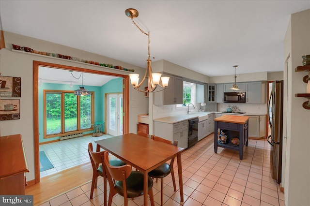dining room featuring light tile patterned flooring, a chandelier, and baseboard heating