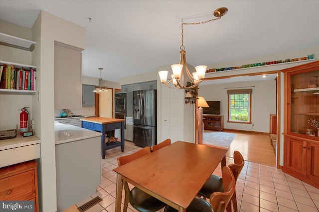 dining area with light tile patterned floors and a chandelier