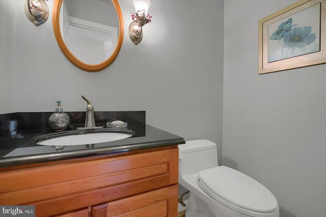 half bathroom with vanity and toilet