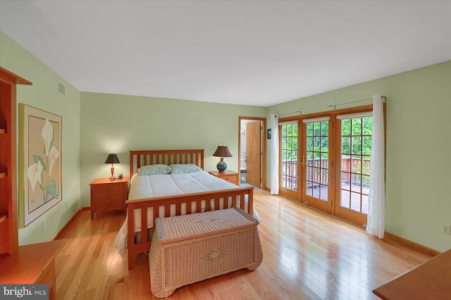 bedroom with baseboards, visible vents, wood finished floors, and access to exterior