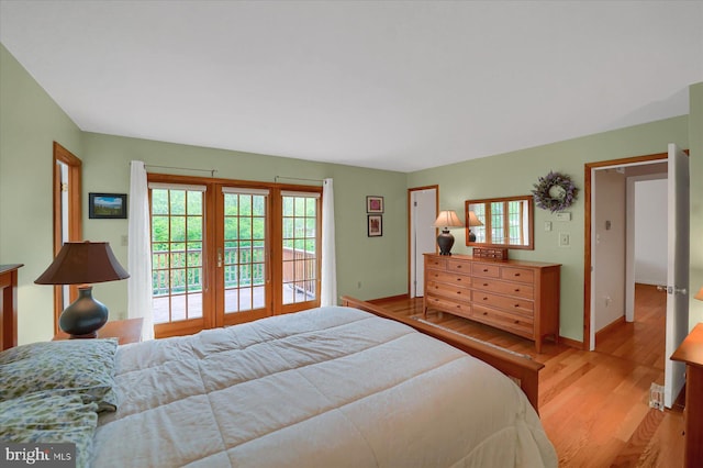 bedroom with baseboards, multiple windows, light wood-style flooring, and access to exterior