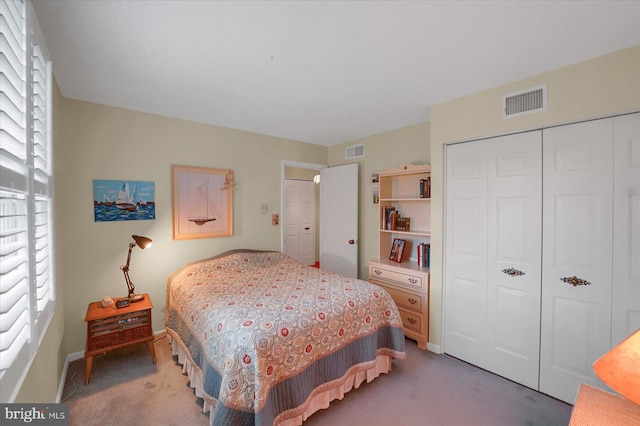 bedroom featuring baseboards, light carpet, a closet, and visible vents
