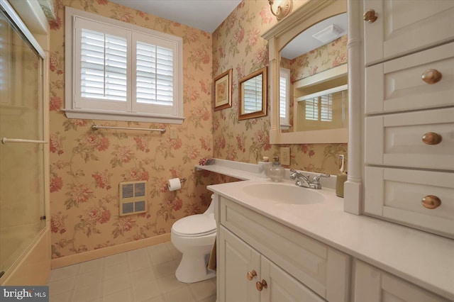 bathroom featuring visible vents, vanity, toilet, baseboards, and a shower with shower door