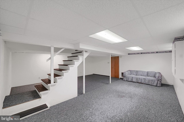 finished below grade area with stairway, a drop ceiling, and carpet flooring