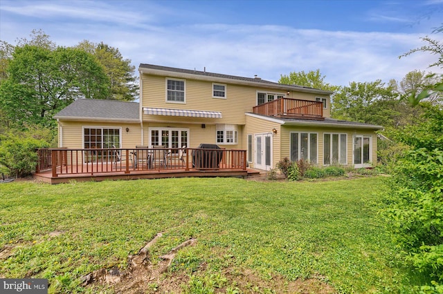back of house featuring french doors, a wooden deck, and a yard