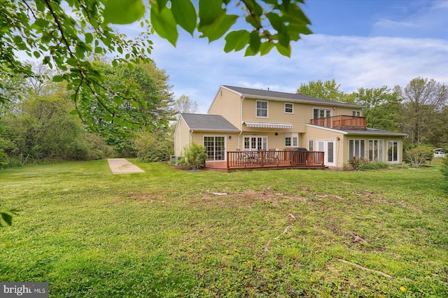 back of house featuring a wooden deck, a yard, and a balcony