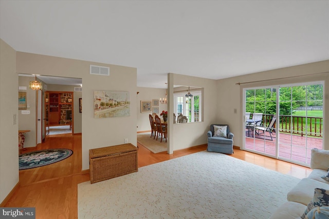 living room with visible vents, wood finished floors, and a chandelier