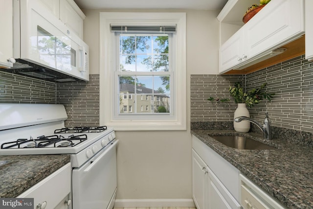 kitchen featuring a sink, white cabinets, backsplash, and white appliances