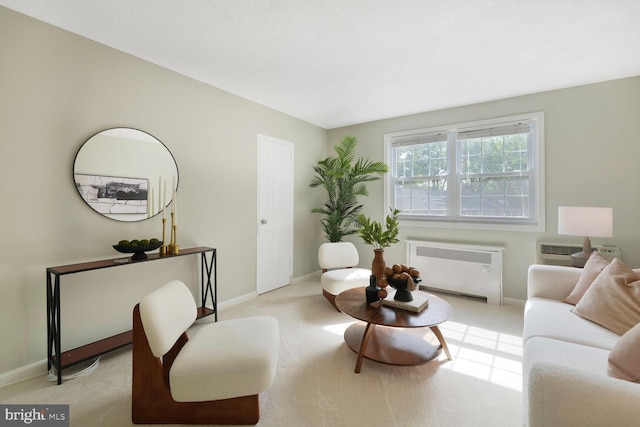 living area featuring radiator, baseboards, light carpet, and an AC wall unit